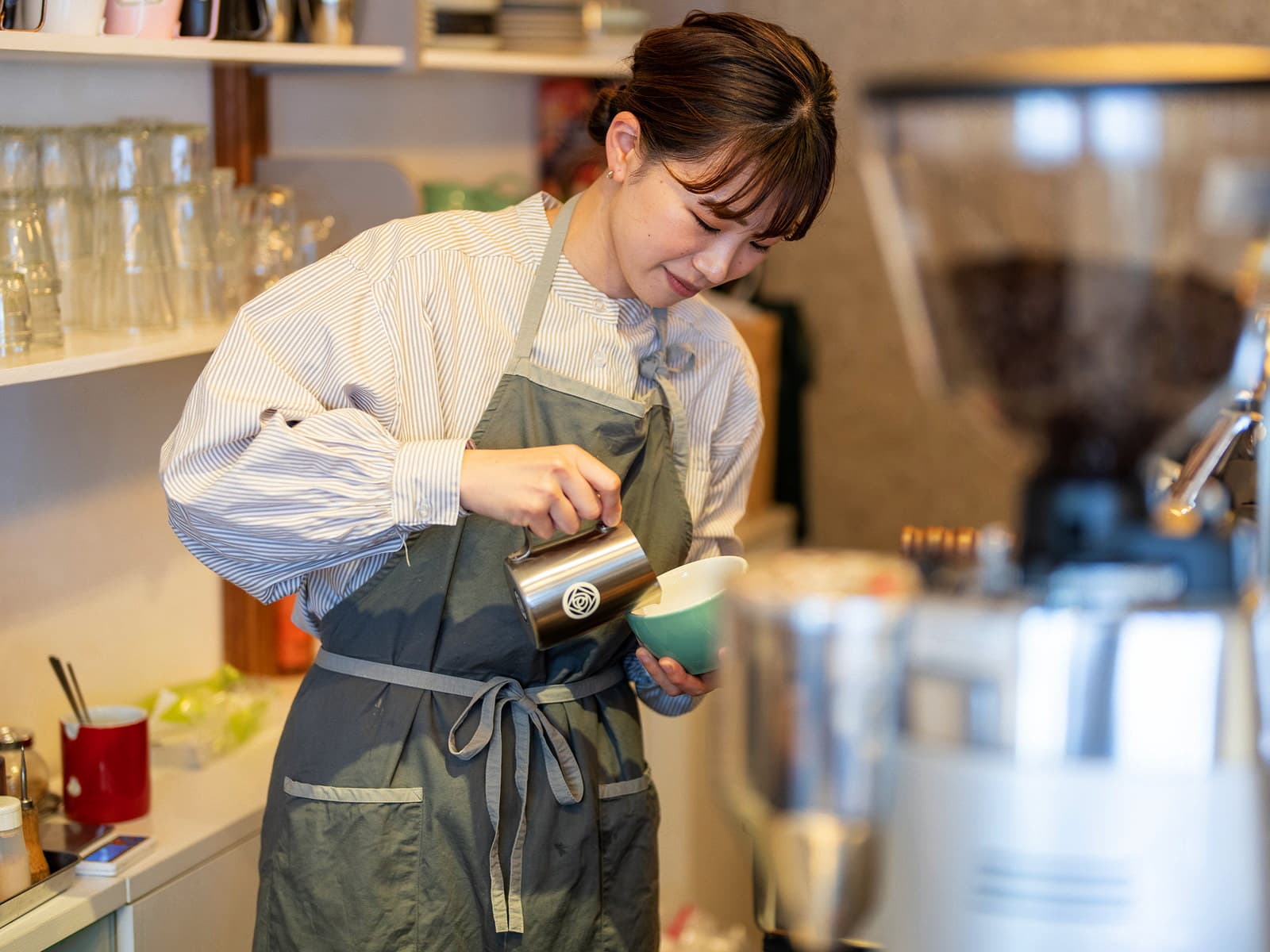 ラテを注ぐロッサコーヒーのバリスタ